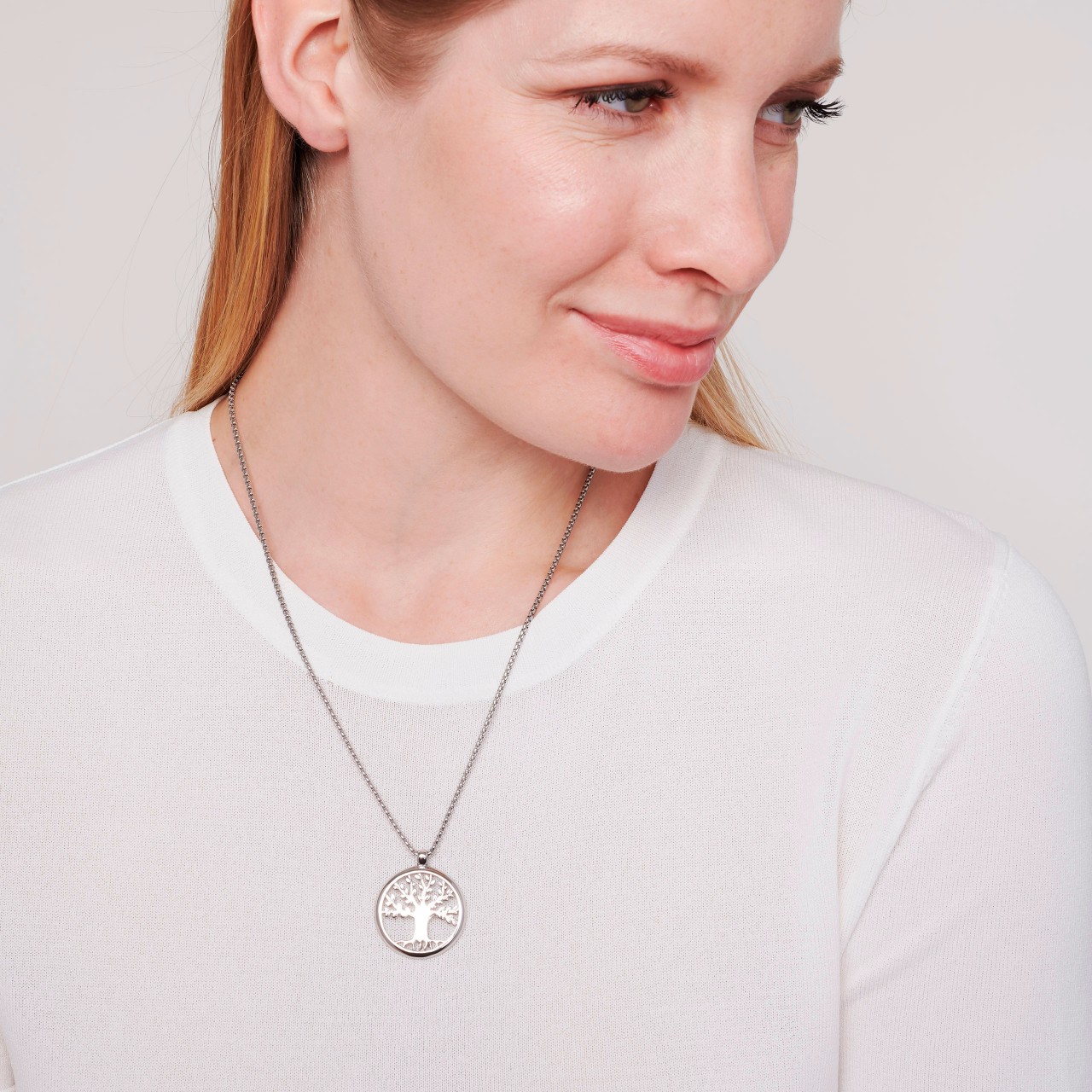 Female model wearing a necklace with a Tree of Life magnetic pendant in stainless steel