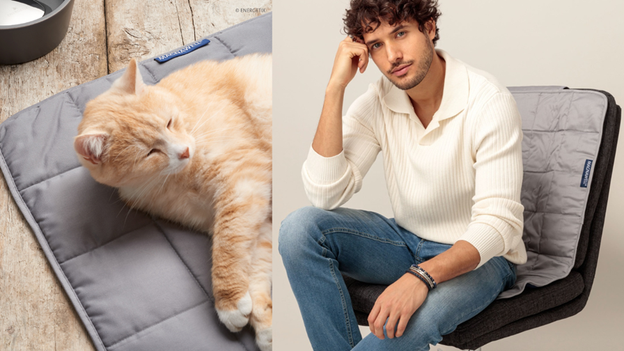 A ginger and white cat laying on the ENERGETIX Magnet Blanket, and a model sitting on a chair that has a Magnet Blanket drapped over it.