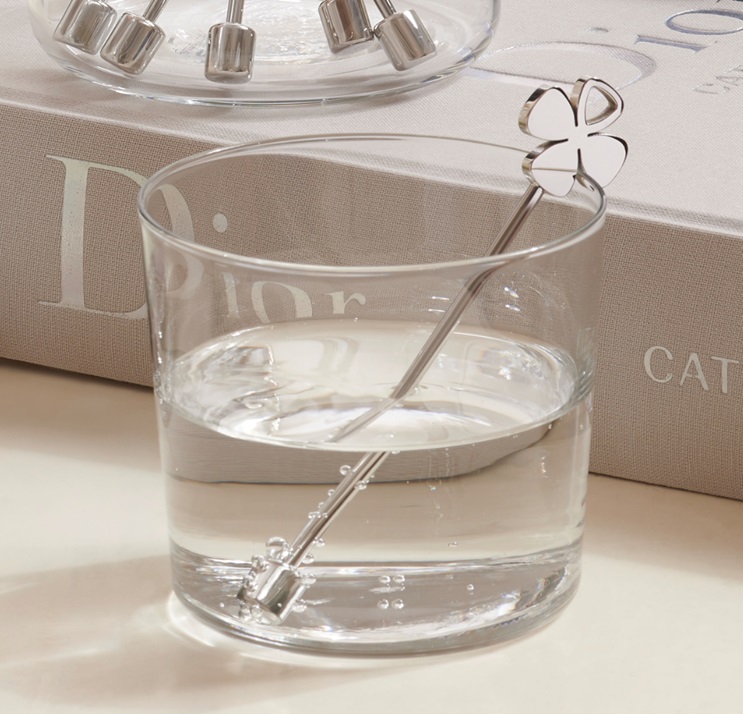 A small glass of water with the ENERGETIX short MagnetStick with a lucky four leaf clover motif