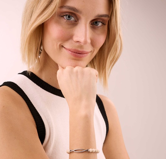A female model weaaring a Gemstone bracelet made of white jasper with an infinity element